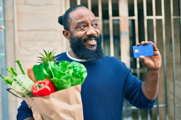 Hombre Afroamericano Con Barba Sosteniendo Bolsa Papel Supermercado Mostrando Tarjeta —  Fotos de Stock