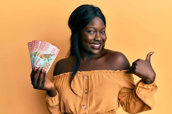 Afričanky Mladá Žena Drží 100 Dolarů Novozélandské Bankovky Ukazující Palec — Stock fotografie
