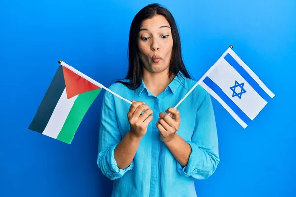 Young Latin Woman Holding Palestine Israel Flags Making Fish Face — Stock Photo, Image