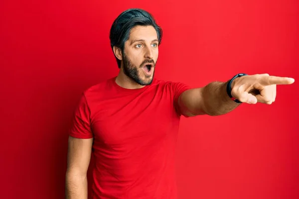 Молодий Іспаномовний Чоловік Повсякденній Червоній Сорочці Вказуючи Пальцем Здивований Попереду — стокове фото