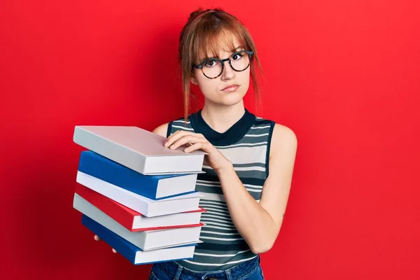 Mujer Joven Pelirroja Sosteniendo Montón Libros Escéptico Nervioso Frunciendo Ceño — Foto de Stock