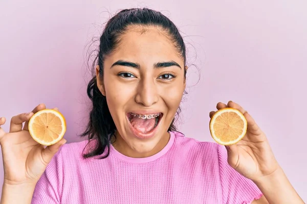 Hispánský Teenager Dívka Chrup Rovnátka Držení Citron Slaví Blázen Ohromen — Stock fotografie