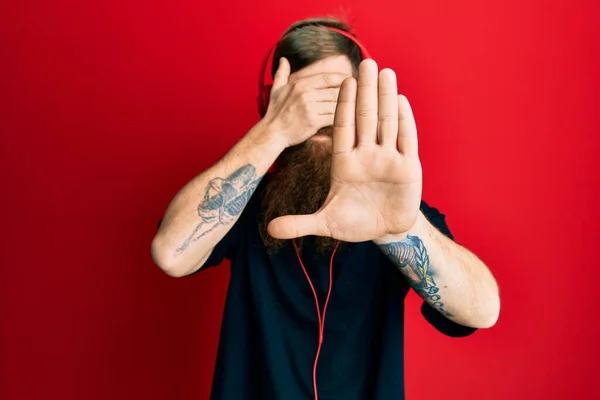 Kızıl Saçlı Uzun Sakallı Müzik Dinleyen Kulaklık Takan Gözleri Elleriyle — Stok fotoğraf