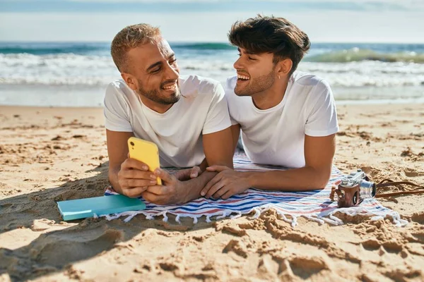 Jong Gay Paar Met Behulp Van Smartphone Liggend Het Zand — Stockfoto