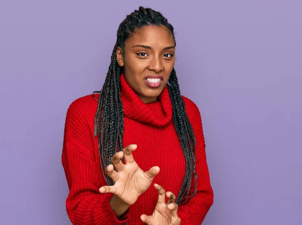 African american woman wearing casual winter sweater disgusted expression, displeased and fearful doing disgust face because aversion reaction. with hands raised