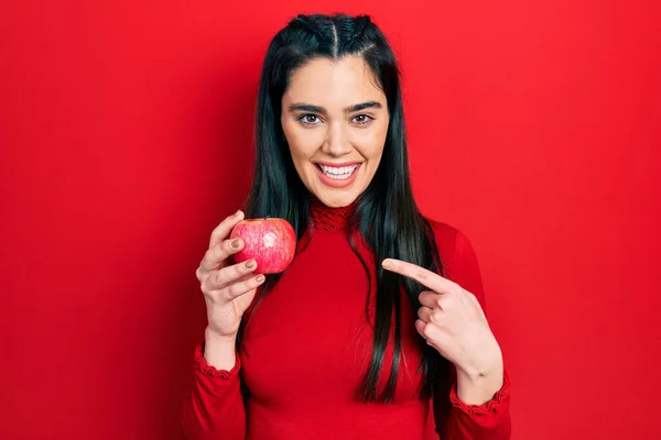 Young Hispanic Girl Holding Red Apple Smiling Happy Pointing Hand — ストック写真