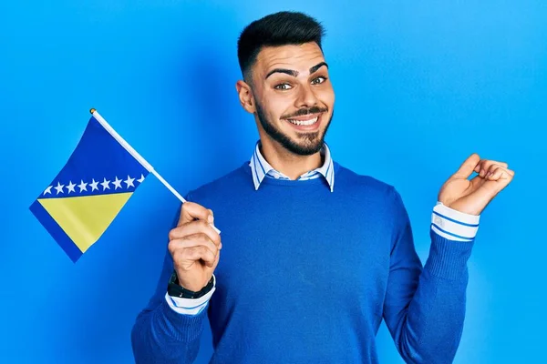 Joven Hombre Hispano Con Barba Sosteniendo Bandera Bosnia Herzegovina Gritando —  Fotos de Stock