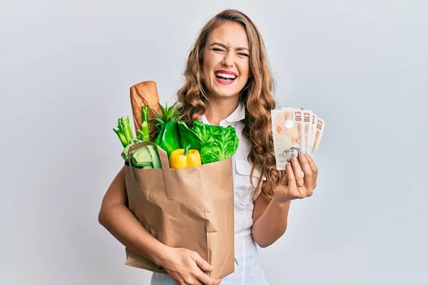 Ung Blond Flicka Som Håller Papperspåse Med Matvaror Och Pounds — Stockfoto