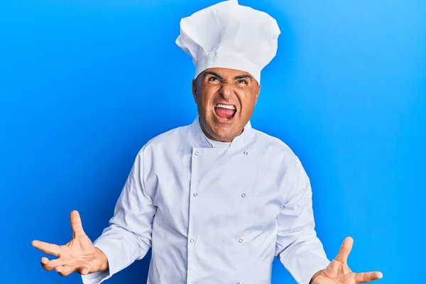 身穿职业厨师制服 头戴一顶疯狂的帽子 满腔热忱地大喊大叫 满腔热忱地举起双臂的中东男子 沮丧的概念 — 图库照片