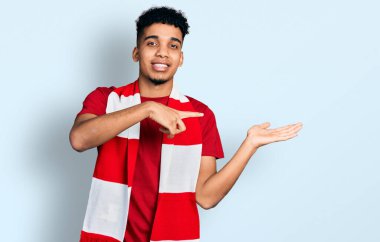 Genç Afro-Amerikan futbolcu holigan adam hayrete düştü ve kameraya gülümsedi.. 