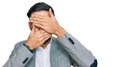 İş kıyafetleri giyen genç İspanyol adam gözlerini ve ağzını elleriyle kapatıyor, şaşırmış ve şok olmuş. duygu gizleme 