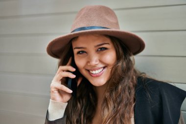 Genç İspanyol turist kadın şehirde akıllı telefondan konuşuyor..