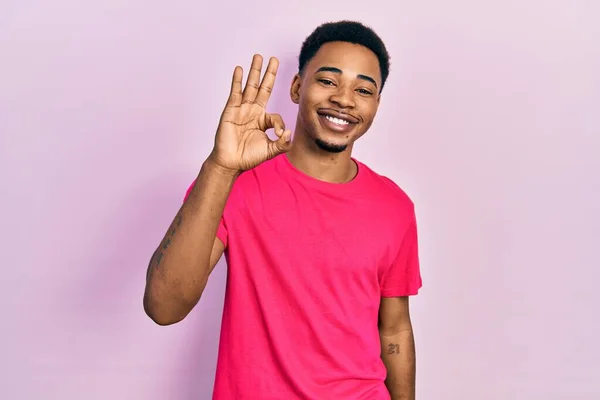 若いアフリカ系アメリカ人の男性は 手と指でOkサインを行う肯定的な笑みを浮かべてカウアキャストシャツを着て 成功した表現 — ストック写真