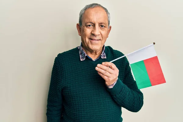 Stilig Senior Man Med Grått Hår Håller Madagascar Flagga Ser — Stockfoto