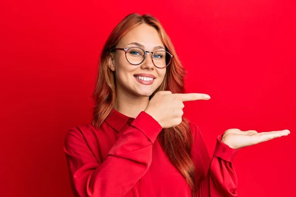 Jonge Mooie Roodharige Vrouw Dragen Casual Kleding Bril Rode Achtergrond — Stockfoto