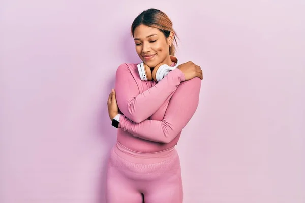 Hermosa Mujer Hispana Vistiendo Ropa Gimnasia Usando Auriculares Abrazándose Feliz — Foto de Stock