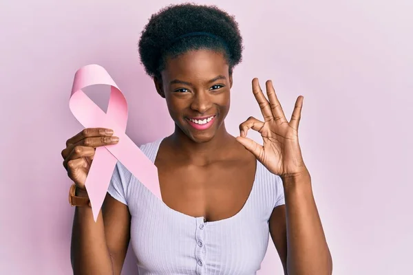 Młoda Afrykańska Dziewczyna Trzyma Różową Wstążkę Raka Robi Znak Palcami — Zdjęcie stockowe