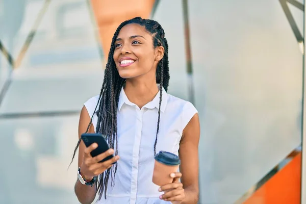 在城市里 年轻的非洲裔美国女人用智能手机喝酒可以带走咖啡 — 图库照片