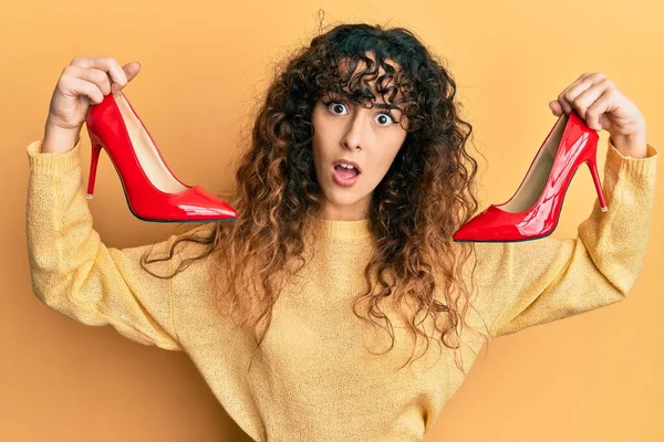 Joven Chica Hispana Sosteniendo Zapatos Rojos Tacón Alto Cara Choque —  Fotos de Stock