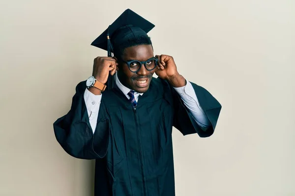 Handsome Black Man Wearing Graduation Cap Ceremony Robe Smiling Pulling — Stock Photo, Image