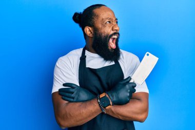 Genç Afro-Amerikalı profesyonel önlük giymiş elinde bıçak olan kızgın ve kızgın çığlık atan sinirli ve öfkeliydi. Öfkeyle bağırıyordu. öfke ve agresif konsept. 