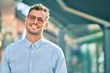 Genç İspanyol işadamı gülümseyerek şehirde mutlu mesut duruyor..