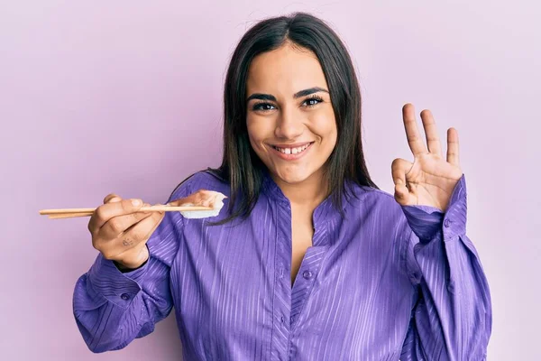 Joven Morena Comiendo Sushi Nigiri Usando Palillos Haciendo Signo Bien — Foto de Stock