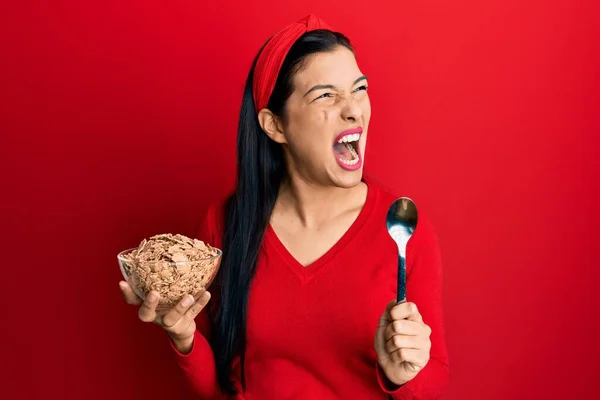 Ung Latinamerikansk Kvinna Med Cornflakes Och Sked Arg Och Galen — Stockfoto