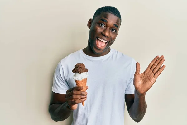 拿着冰淇淋的年轻的非洲裔美国人 带着快乐的笑容和高傲的表情庆祝着他们的成就 — 图库照片