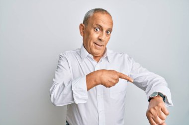 Yakışıklı, beyaz tişört giyen, acele eden, saati, sabırsızlığı, son teslim tarihini geciktirdiği için kızgın ve sinirli bir adam. 