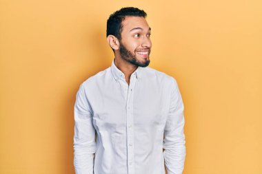 Sakallı, iş gömleği giyen, gülümseyen, yan bakıp düşünen İspanyol bir adam.. 