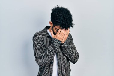 Sakallı, gözlüklü, suratını elleriyle kapatıp ağlayan genç bir Arap. depresyon kavramı. 