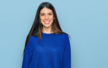 Yüzünde mutlu ve havalı bir gülümseme olan gündelik kıyafetler giyen genç İspanyol kadın. şanslı kişi. 