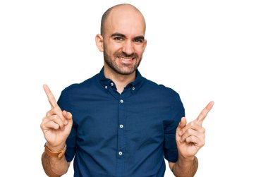 Gündelik kıyafetler giyen, kendine güvenen, parmaklarını farklı yönlere çeviren genç İspanyol adam. reklam için kopyalama alanı 