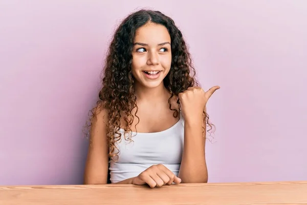 Έφηβος Ισπανόφωνος Κορίτσι Φορώντας Casual Ρούχα Κάθεται Στο Τραπέζι Δείχνοντας — Φωτογραφία Αρχείου