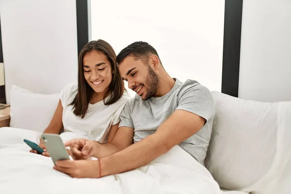 Jovem Casal Latino Usando Smartphone Deitado Cama Casa — Fotografia de Stock