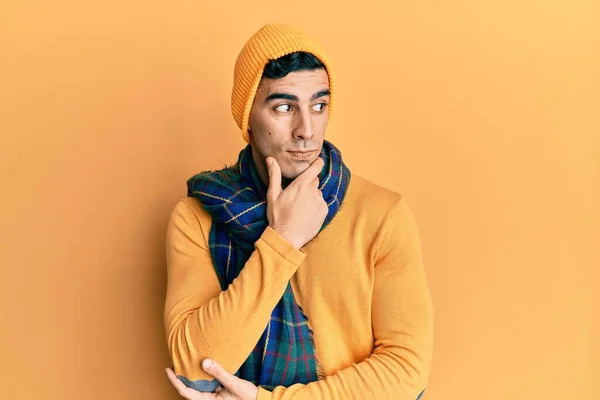 Handsome Hispanic Mann Iført Ullhatt Vinterskjerf Med Hånd Hake Tenker – stockfoto