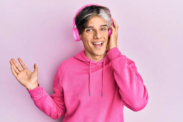 Joven Hispano Escuchando Música Usando Auriculares Celebrando Logros Con Sonrisa —  Fotos de Stock