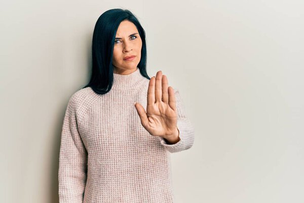 Young caucasian woman wearing casual winter sweater doing stop sing with palm of the hand. warning expression with negative and serious gesture on the face. 