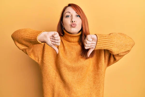 Beautiful Redhead Woman Doing Negative Thumbs Gesture Looking Camera Blowing — Stock Photo, Image