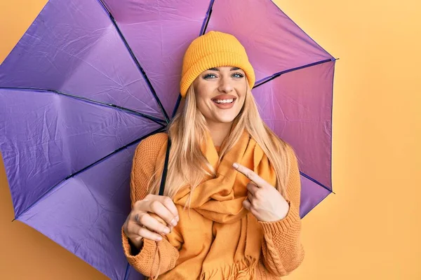 Young Caucasian Woman Holding Purple Umbrella Smiling Happy Pointing Hand — Stock Photo, Image