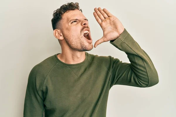 若いヒスパニック系の男はカジュアルな服を叫んで大声で口の上に手で横に叫んで身に着けている コミュニケーションの概念 — ストック写真
