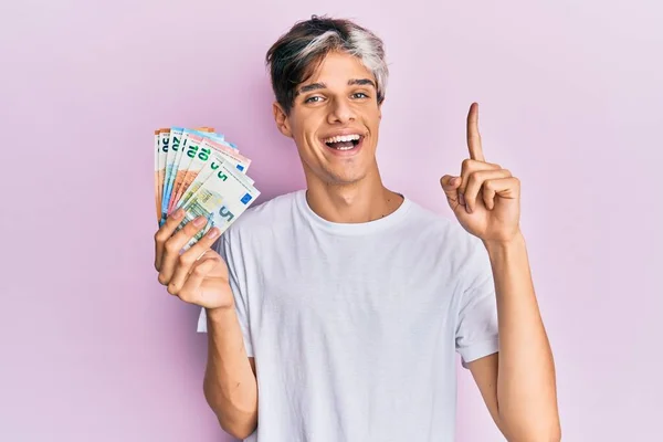 Молодий Іспаномовний Чоловік Тримає Євро Банкноти Посміхаючись Ідеєю Або Питанням — стокове фото