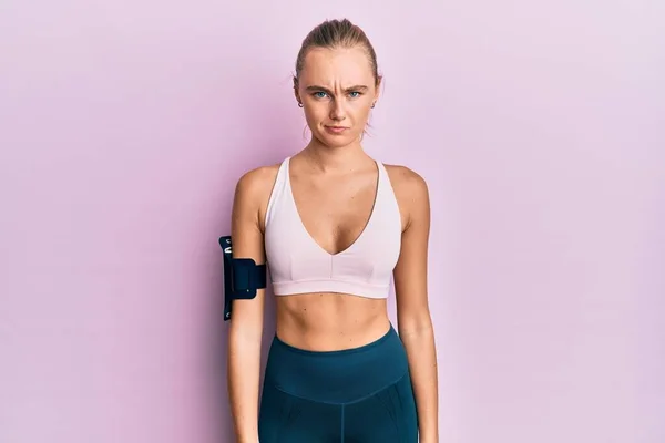 Vacker Blond Kvinna Bär Sportkläder Och Armband Skeptisk Och Nervös — Stockfoto