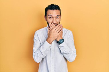 İş gömleği giyen İspanyol sakallı adam ağzını yanlışlıkla ellerle kapatırken şok oldu. gizli kavram. 