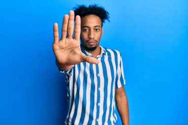 Sakallı, sıradan çizgili tişörtlü genç Afro-Amerikan bir adam avucunun içi gibi şarkı söylemeyi kesiyor. Yüzünde olumsuz ve ciddi bir jest olan uyarı ifadesi. 