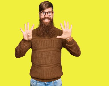 Genç İrlandalı kızıl elbiseli ve gözlüklü adam dokuz numarayı gösterip işaret ederken kendinden emin ve mutlu gülümsüyor.. 