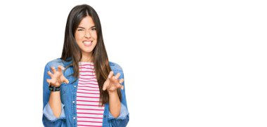 Genç esmer kadın gündelik kıyafetler giyip gülümsüyor. Pençe hareketlerini kedi gibi yapıyor. Agresif ve seksi bir ifade. 