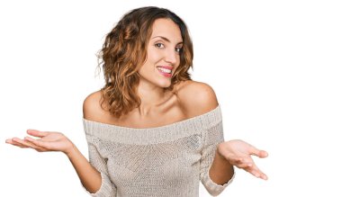 Gündelik kıyafetler giyen, kafası karışık, kolları ve elleri havada, güzel, beyaz bir kadın. şüphe kavramı. 