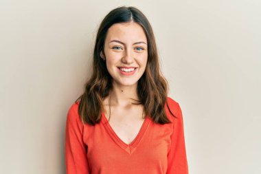 Genç esmer kadın mutlu ve havalı bir gülümsemesi olan günlük kıyafetler giyiyor. şanslı kişi. 